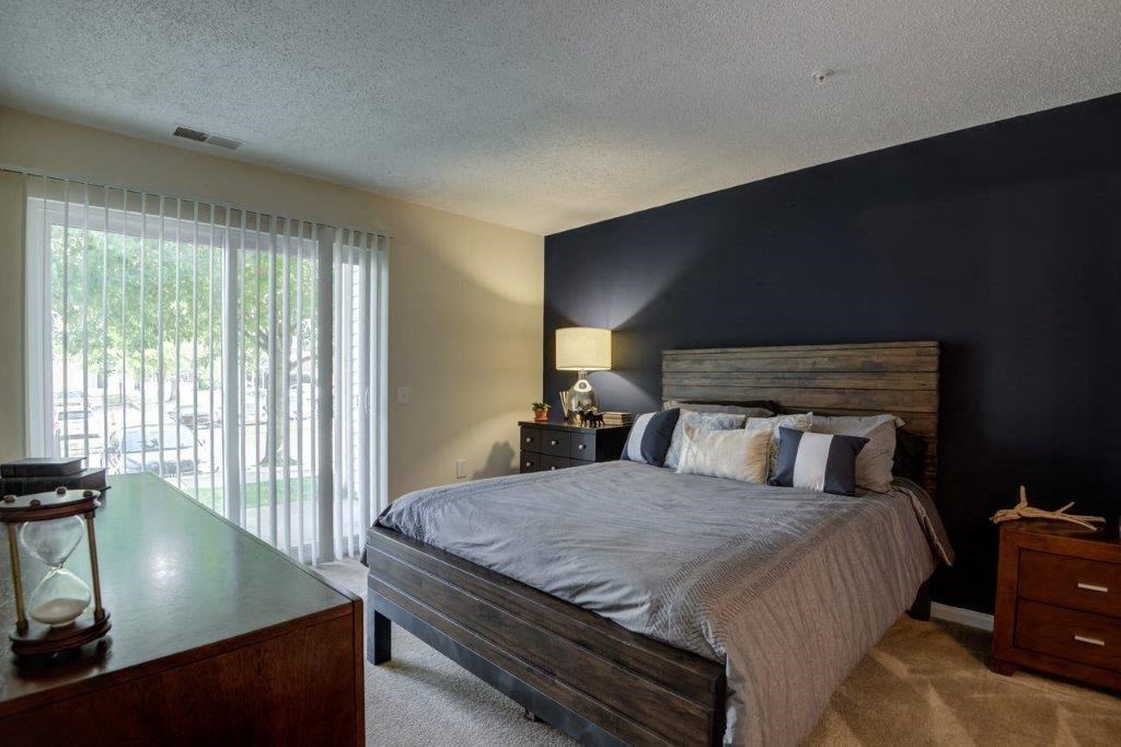 a bedroom with a bed and a black accent wall