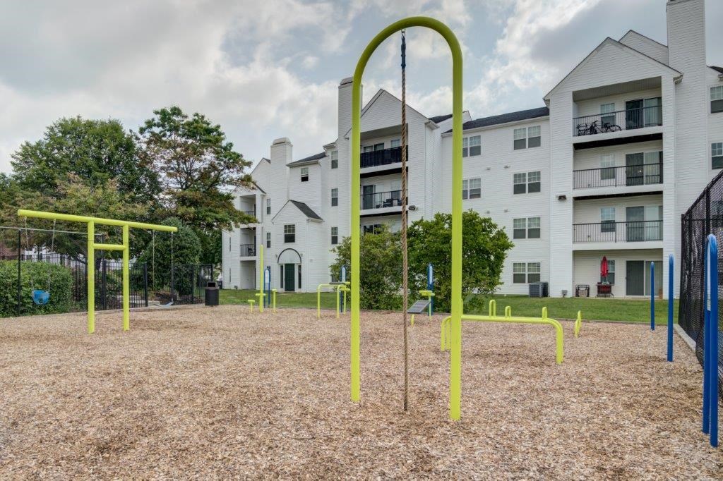 an empty playground in front of an apartment building
