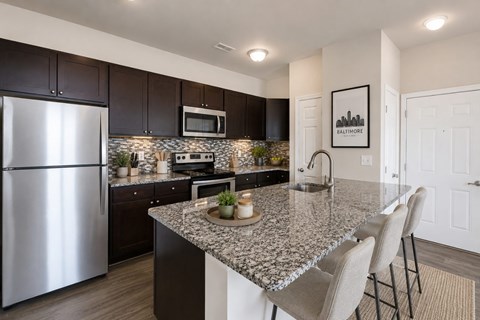A kitchen with granite countertops and a stainless steel refrigerator.