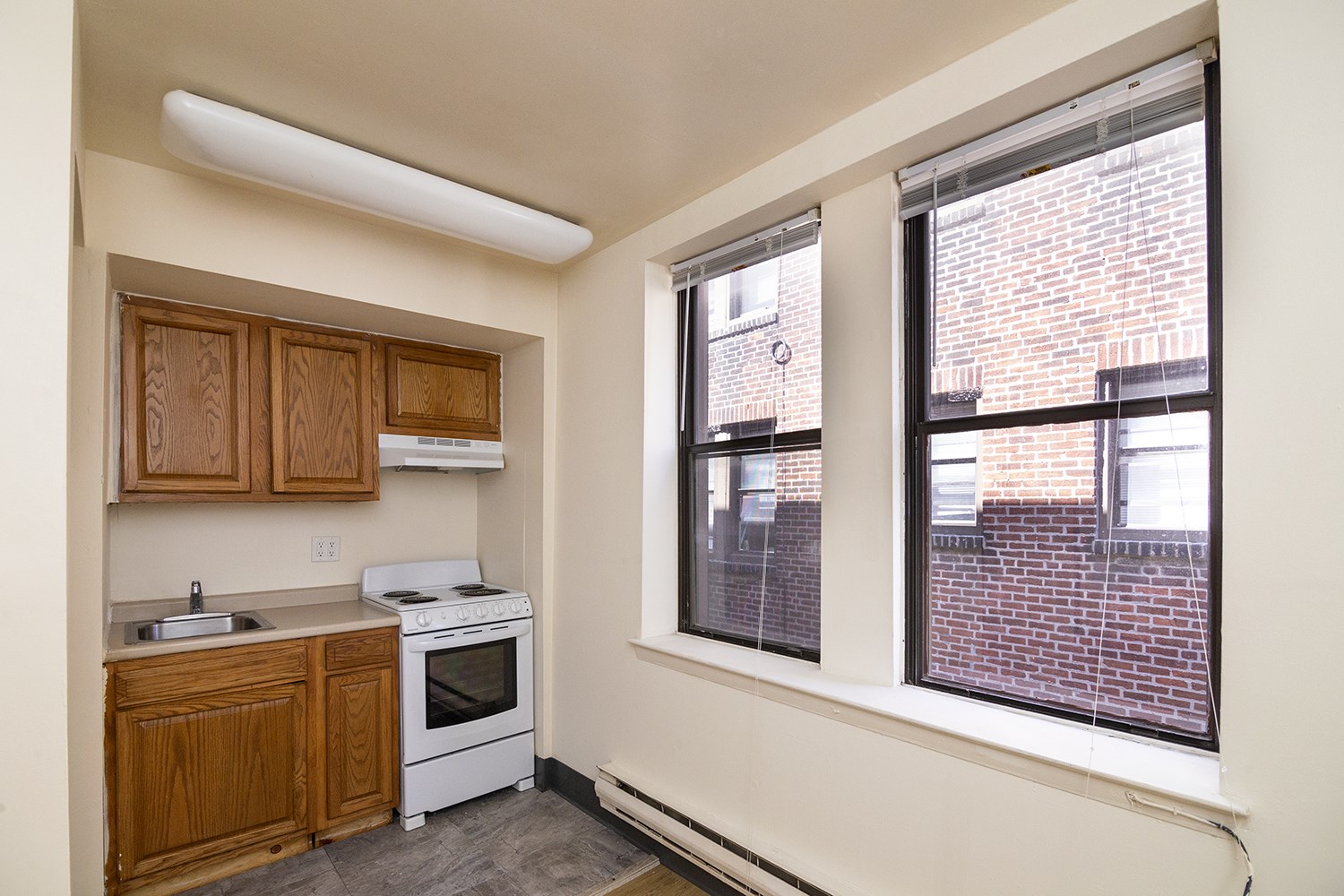 A kitchen with wooden cabinets and a white oven.