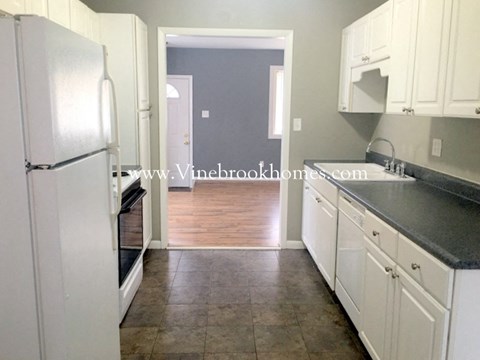 a small kitchen with white cabinets and stainless steel appliances