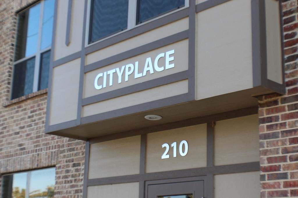 A building with a sign that says Cityplace and the number 210  at City Place Apartments Denton, TX 