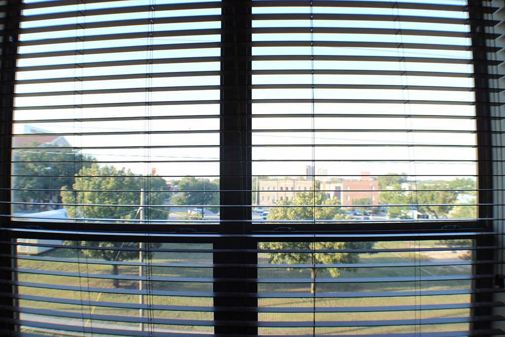 A view of a street through a window with blinds at City Place Apartments, Texas, 76201