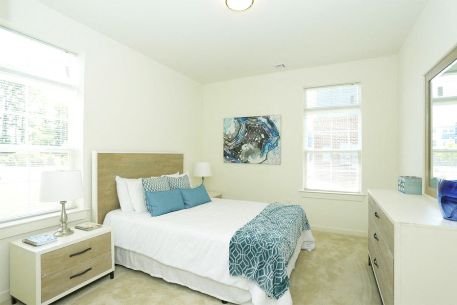 a bedroom with a bed and two windows