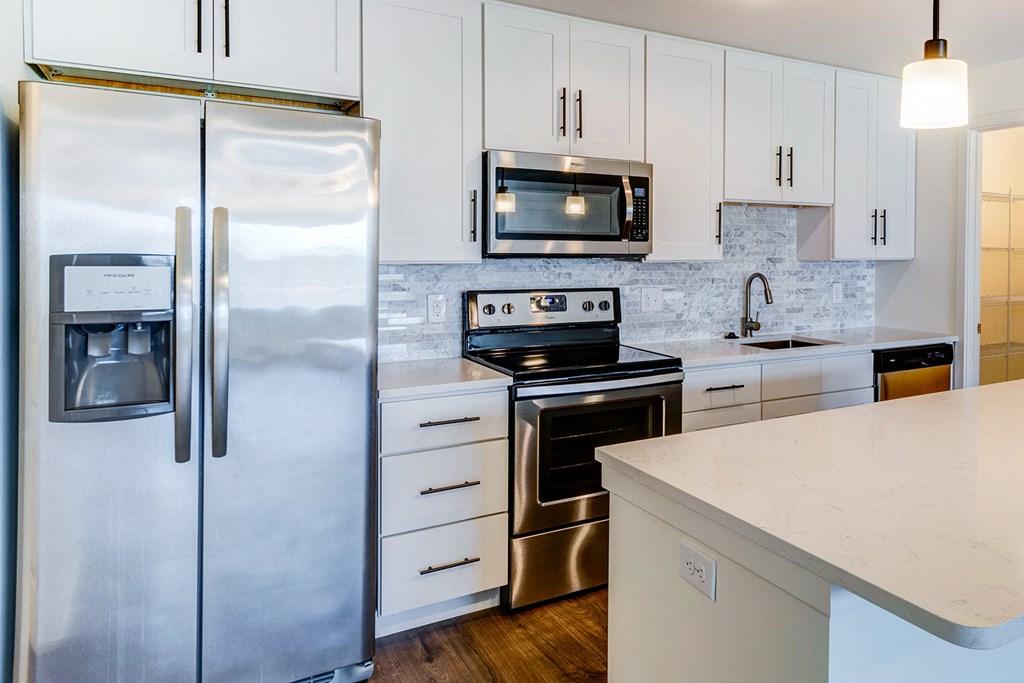 a kitchen with stainless steel appliances and white cabinets
