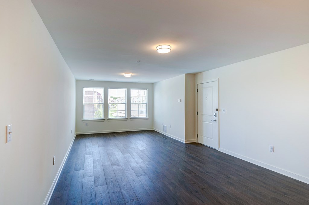 an empty living room with white walls and wood flooring