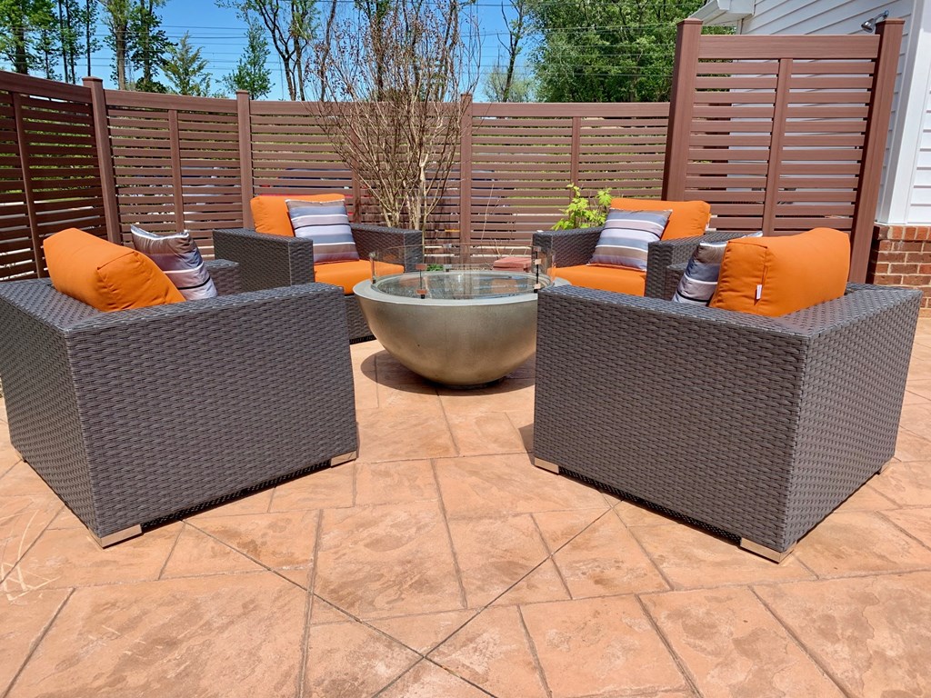 a seating area with chairs and a bowl on a patio