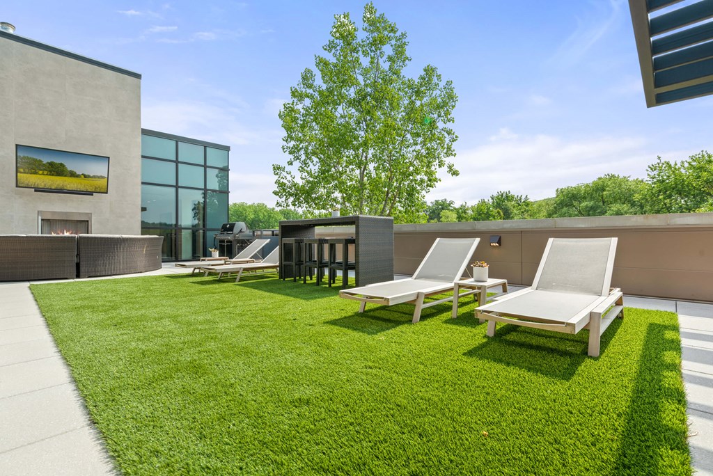 A rooftop patio with four lounge chairs and a small bar with barstools on artificial turf. at Keva Flats, Exton, PA, 19341