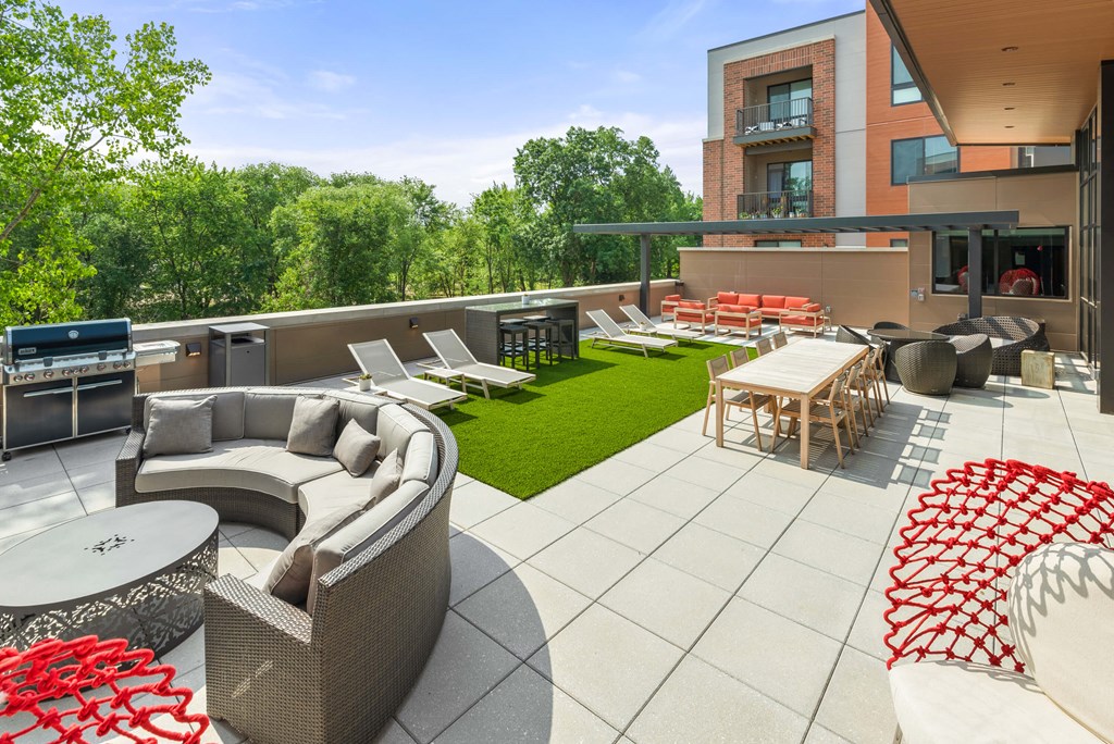 A roof-top terrace with a grilling station, fire pits, a comfortable seating area, chairs, tables, and lounge chairs on artificial turf. at Keva Flats, Pennsylvania