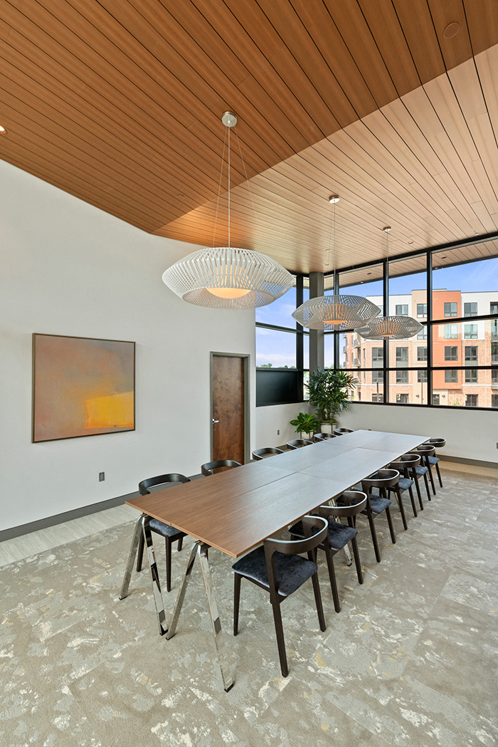 A private conference room for Keva Flats residents with a 12-seat table, modern lights, and large windows. at Keva Flats, Pennsylvania, 19341