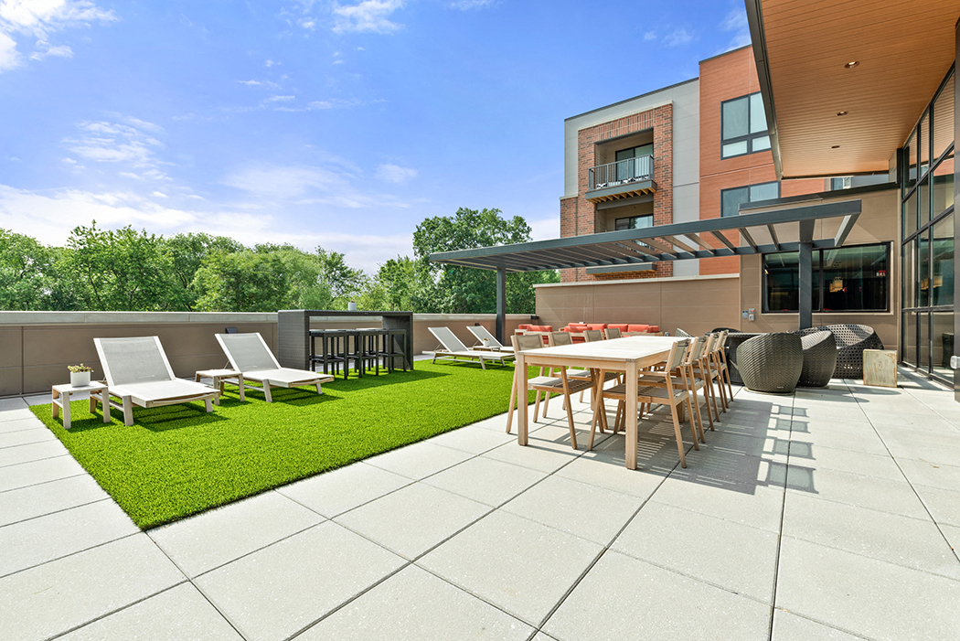 A roof-top terrace with a grilling station, fire pits, a comfortable seating area, chairs, tables, and lounge chairs on artificial turf. at Keva Flats, Exton, 19341
