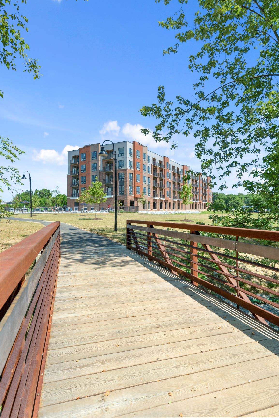 A bridge leading to a walking trail surrounded by grass and trees near Keva Flats. at Keva Flats, Exton