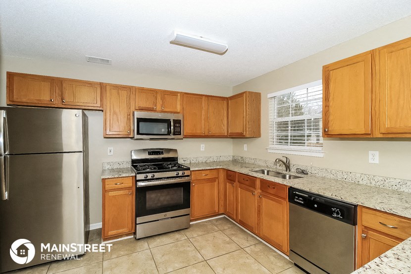a kitchen with wooden cabinets and stainless steel appliances