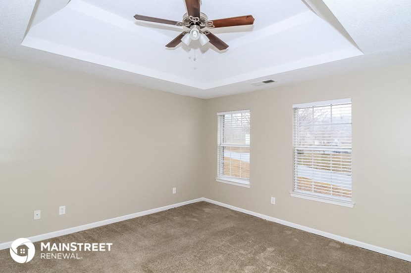 the living room of a home with a ceiling fan