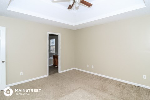 a living room with carpet and a ceiling fan