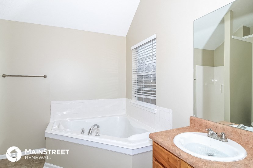 a bathroom with a tub and a sink and a mirror