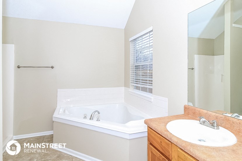 a bathroom with a tub and a sink and a mirror