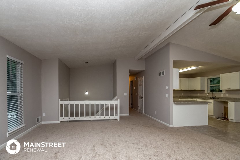 the living room and kitchen of an empty house