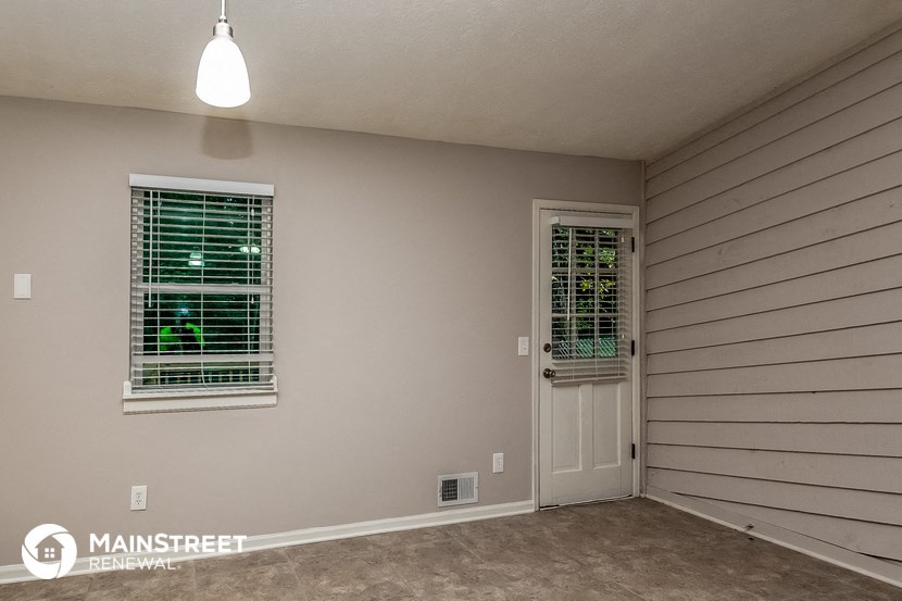 the living room of a house with a white door and window