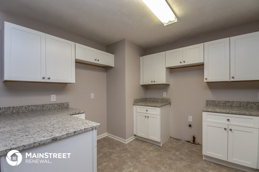 a kitchen with white cabinets and granite counter tops