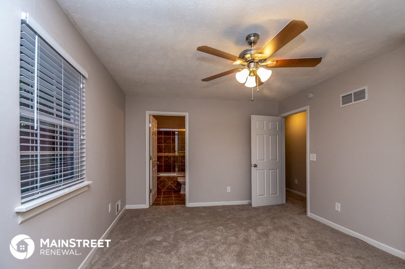 an empty room with a ceiling fan and a door to a closet