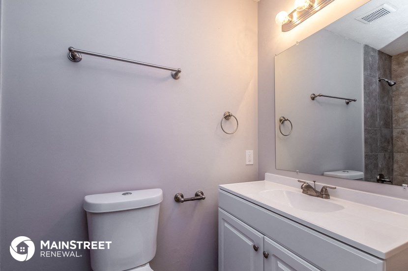 a bathroom with a toilet and a sink and a mirror