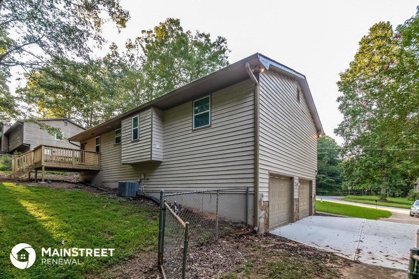 the front of a house with a garage and a sidewalk