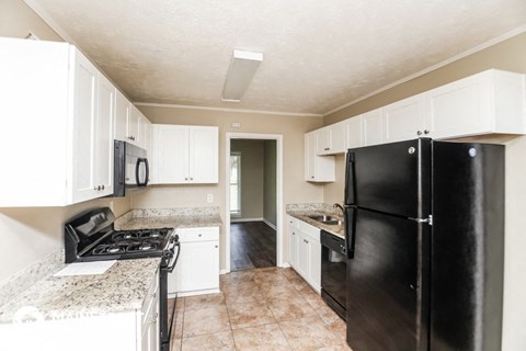 a kitchen with black appliances and white cabinets