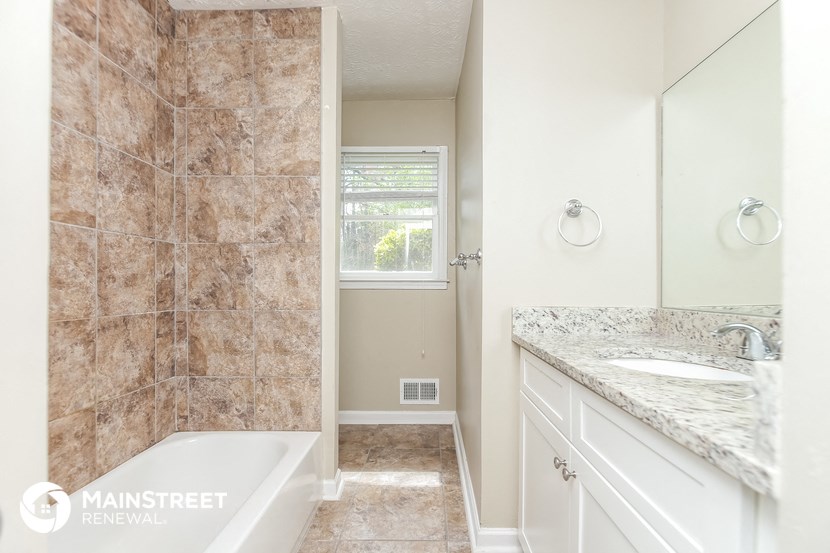 a bathroom with a tub and a sink and a mirror