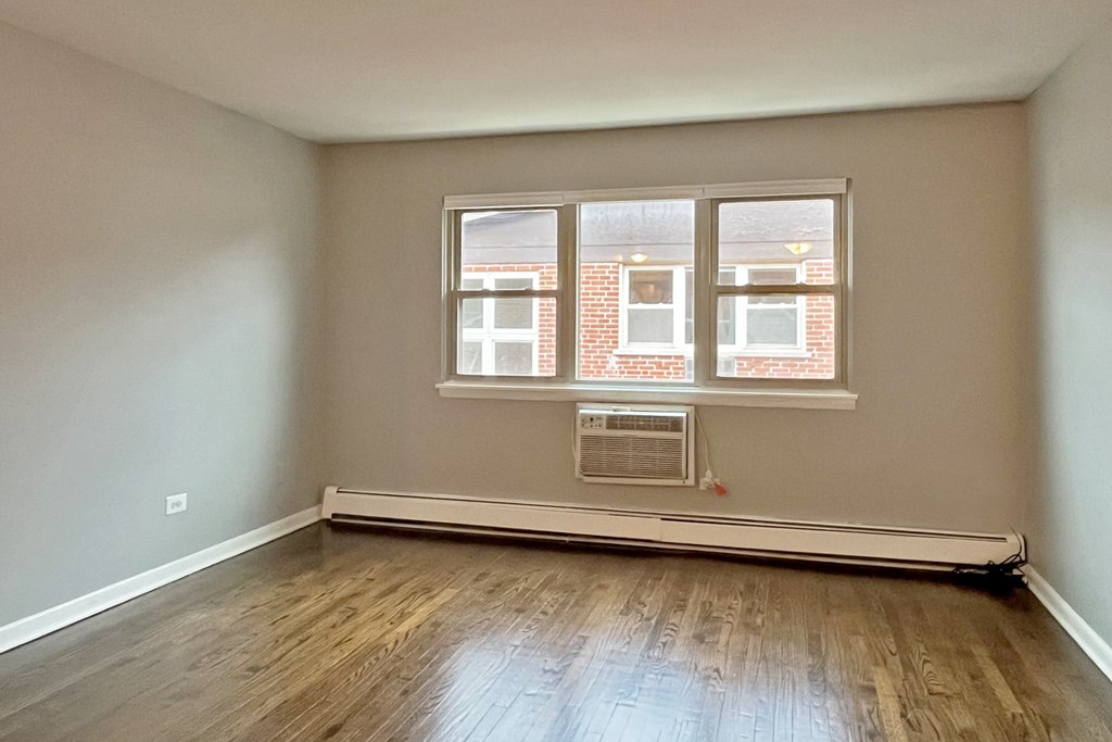 A room with a window and a radiator on the floor.