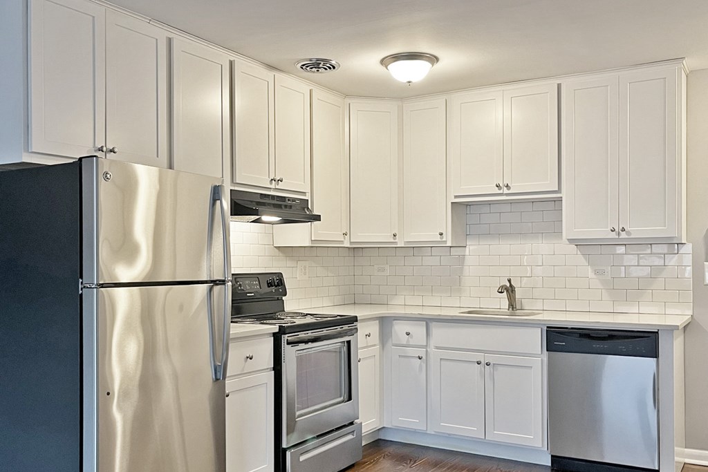 A kitchen with white cabinets and appliances.