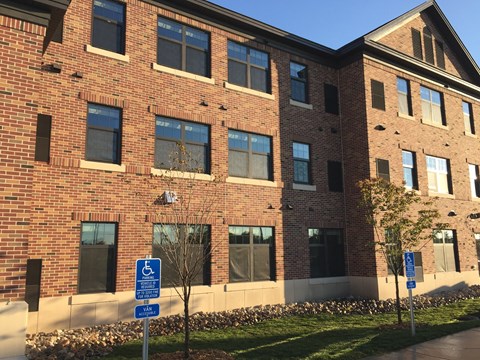A red brick building with a blue and white handicap sign in front.