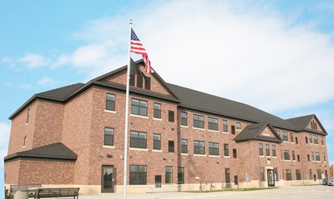 A large brick building with an American flag on top.