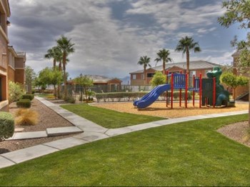 Playground with slide and grassy area at Villanova Apartments - Photo Gallery 2