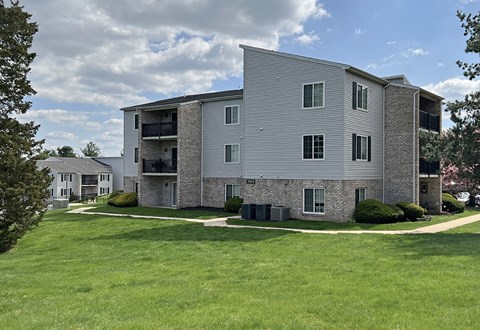 an apartment building with a green lawn in front of it