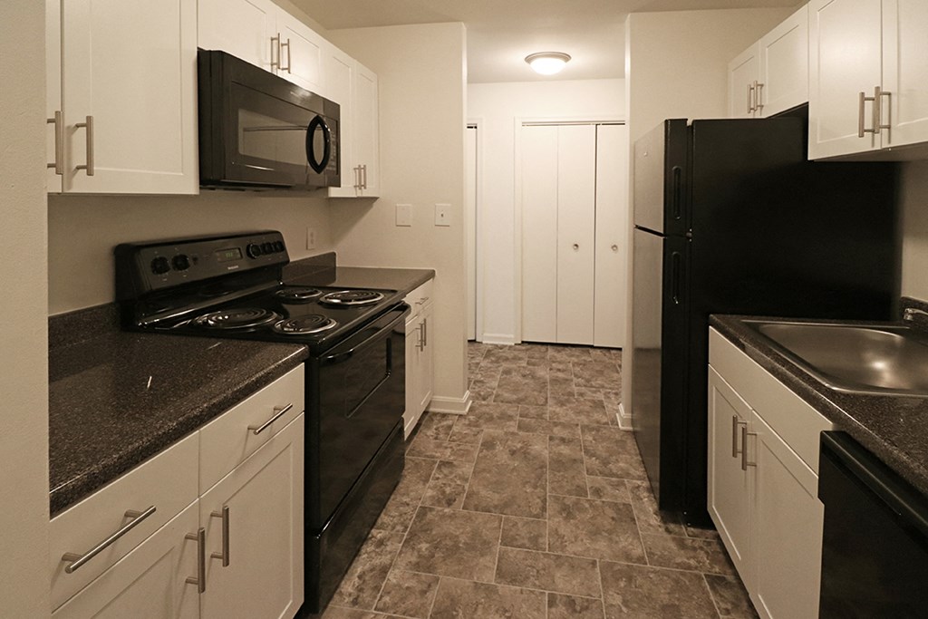 a kitchen with black appliances and white cabinets