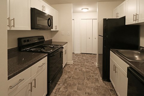 a kitchen with black appliances and white cabinets