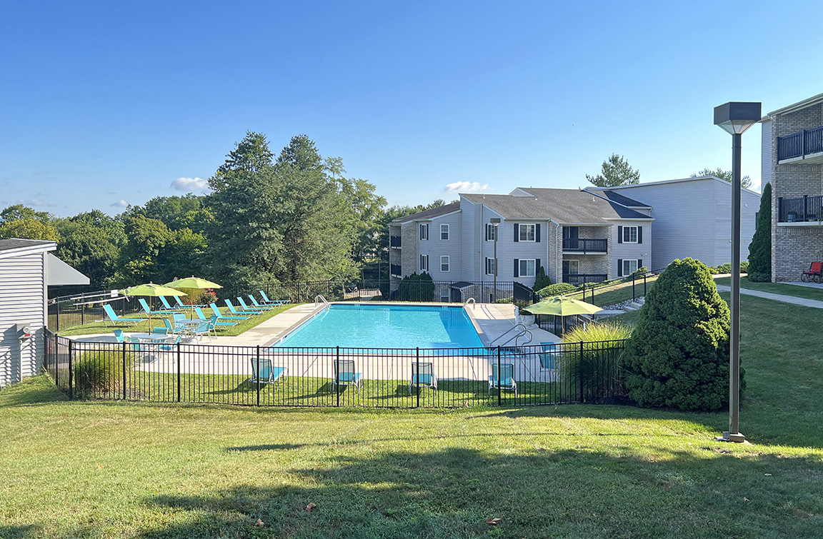 an aerial view of a swimming pool in front of an apartment building