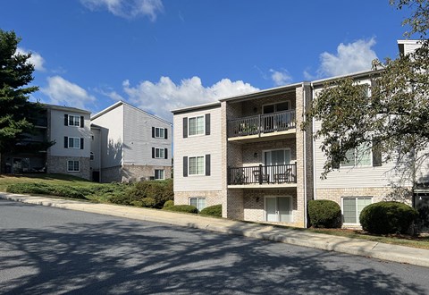 a street view of an apartment building on a sunny day