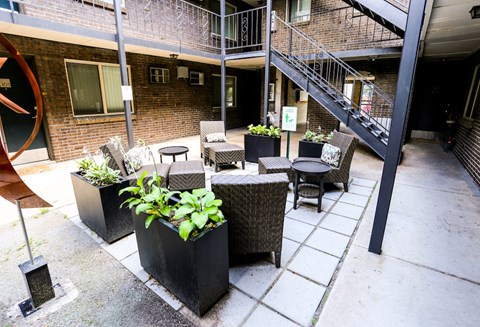 an outside patio with tables and chairs and a brick building