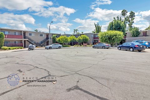 a parking lot in front of a building with cars parked