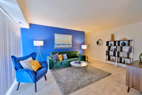 a living room with a blue accent wall and a green couch