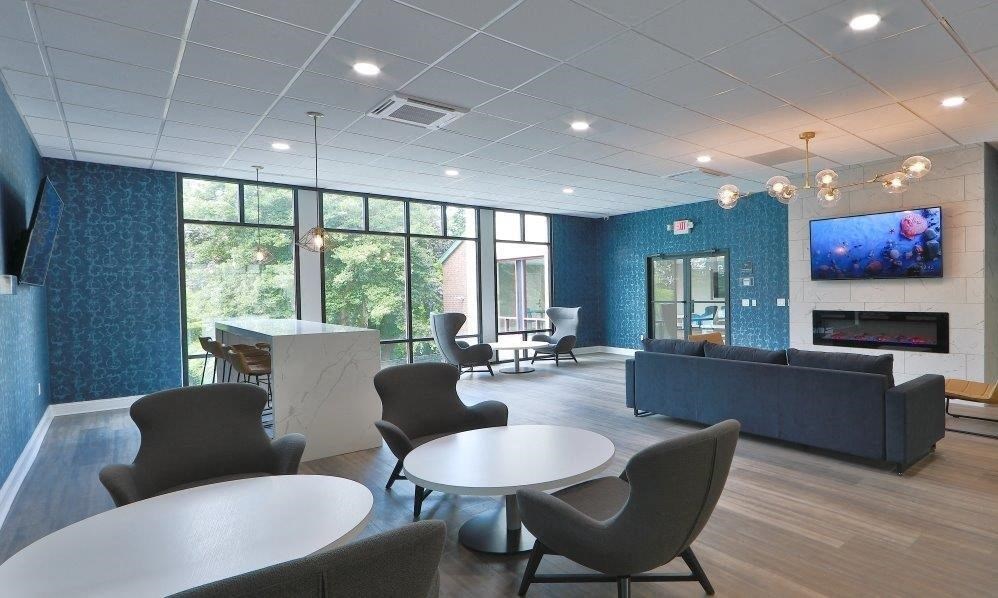 a living room with tables and chairs and a television