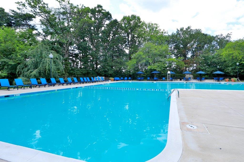 a large blue pool with blue chairs around it