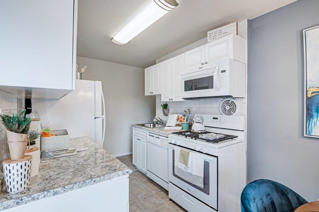 a kitchen with white appliances and granite counter tops