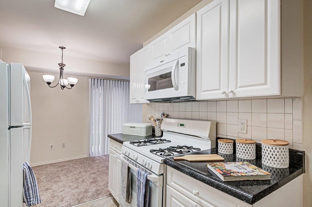 a kitchen with white cabinets and a stove and a refrigerator