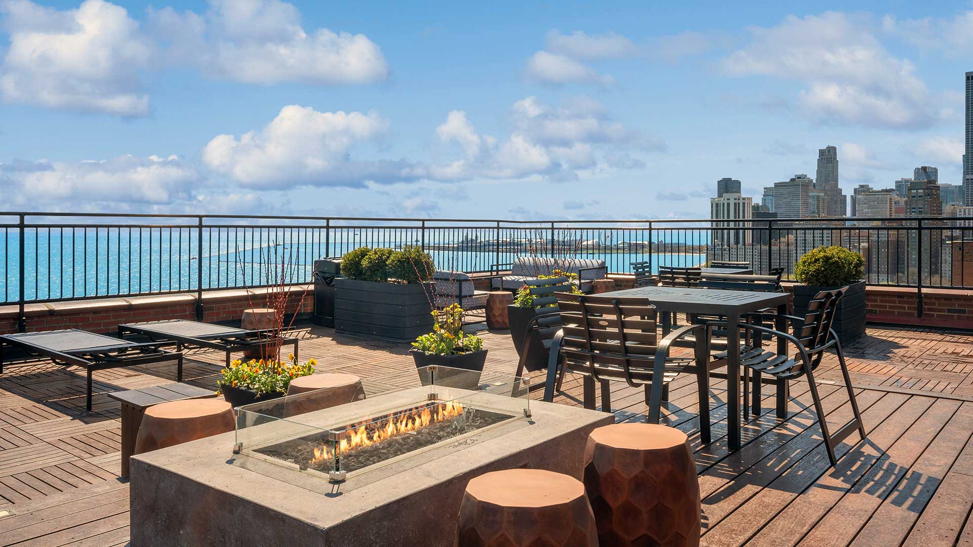 Looking across the firepit on the roof deck with Lake Michagn and the Chicago skyline in the background.