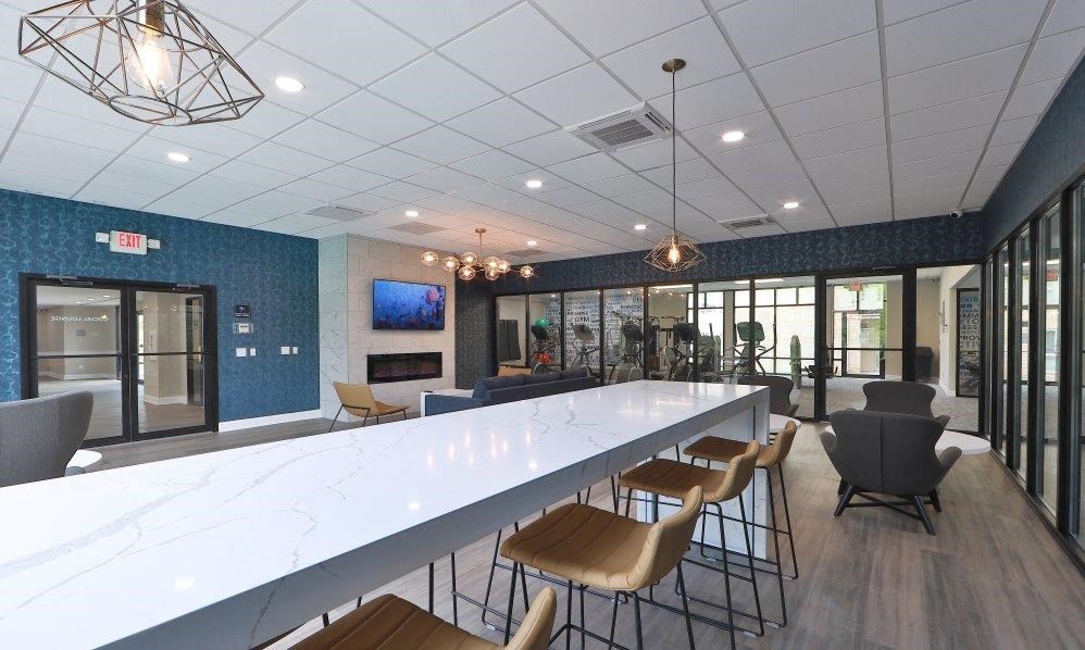 a lobby with a long white counter and chairs