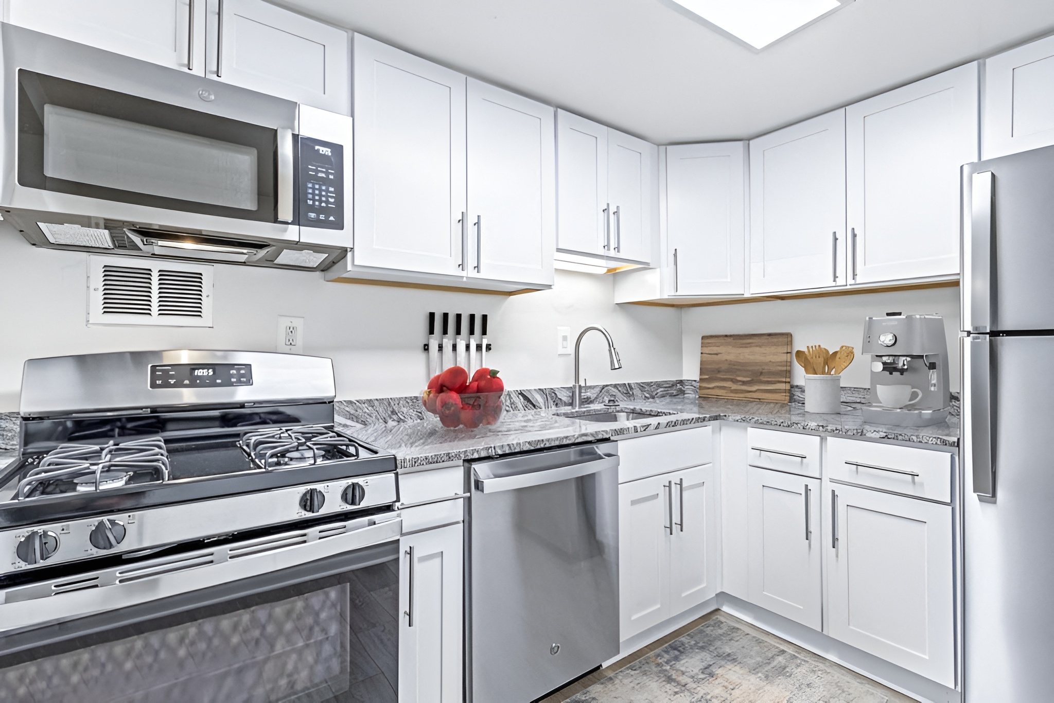 a kitchen with stainless steel appliances and white cabinets