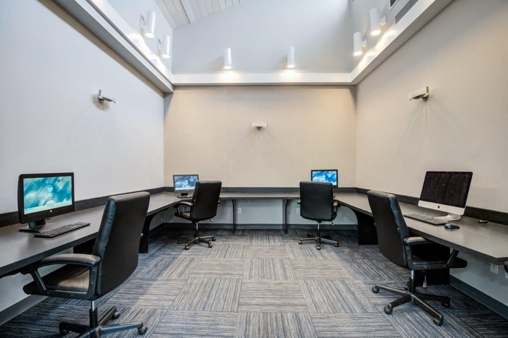 a large conference room with computer desks and chairs
